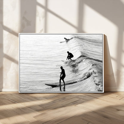 Black and white photo of surfers riding waves in a moody, high-contrast scene, ideal for modern coastal or surf-inspired home decor.