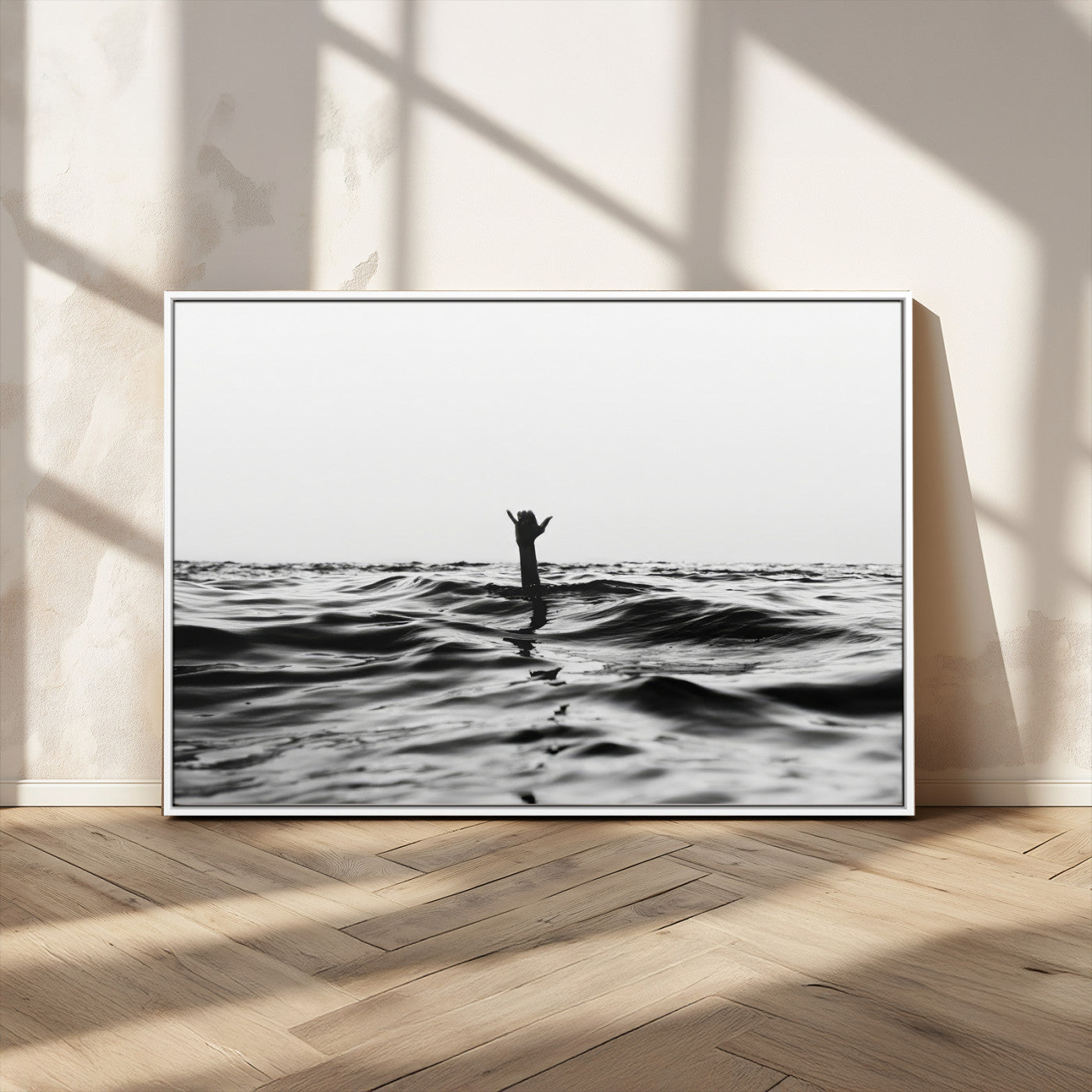 Black and white ocean with a hand making a surfer sign among dark waves, creating a dramatic and minimalist seascape with bold contrast.