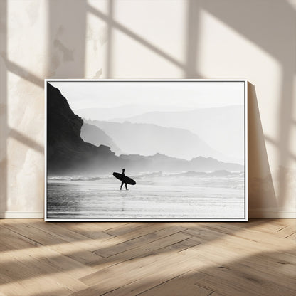 A lone surfer walking along a misty beach with cliffs in the background, carrying their board, capturing a serene and minimal ocean moment.