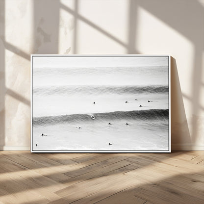 A monochrome photograph of swimmers gliding through gentle ocean waves, evoking a sense of calm and movement.