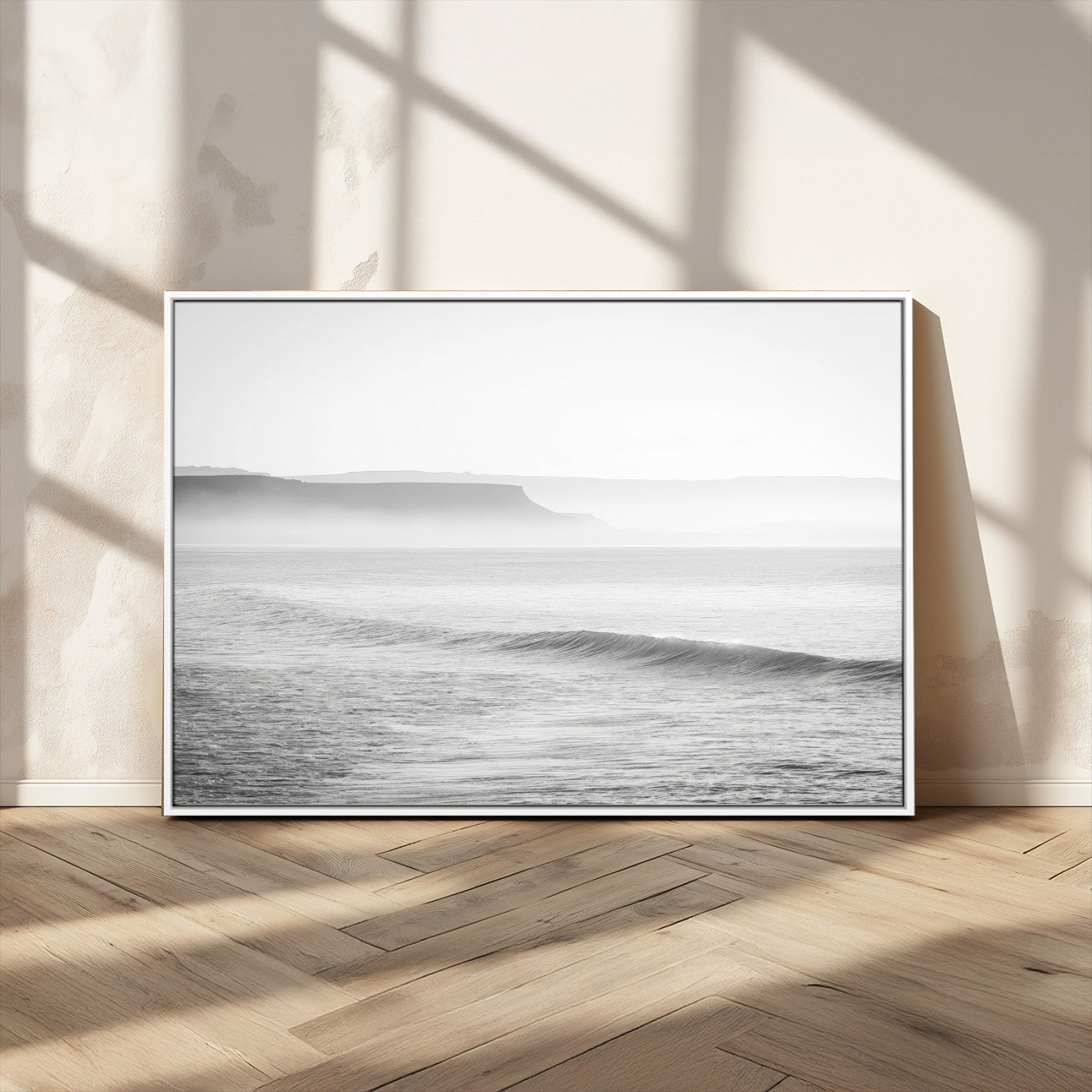 A black and white minimalist seascape featuring soft rolling waves and misty distant cliffs, creating a serene and timeless coastal atmosphere.