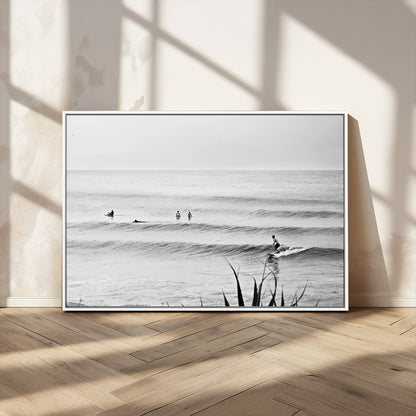 Monochrome canvas of surfers on calm ocean waves, ideal for minimalist coastal or beach-inspired interior decor.