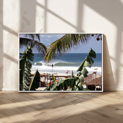 Canvas wall art of a tropical surf scene framed by palm trees, with a surfer on the shore and waves rolling in, ideal for beach-themed decor.