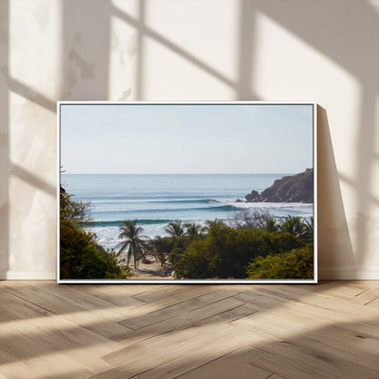 View of calm ocean waves with palm trees and a tropical coastline, ideal for coastal boho or beach-themed wall decor.