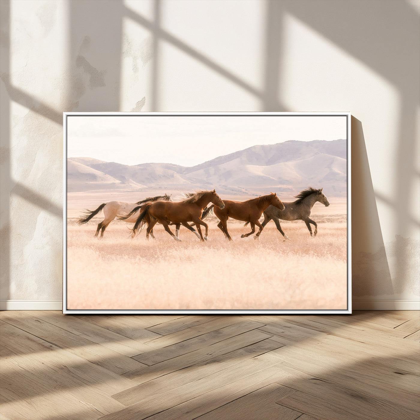 A herd of wild horses galloping through a sunlit desert plain with mountains in the background, perfect for rustic or western-themed wall decor.