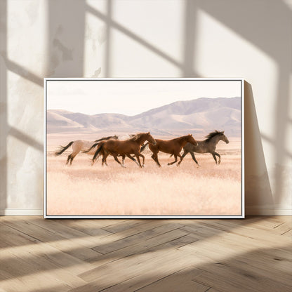 A herd of wild horses galloping through a sunlit desert plain with mountains in the background, perfect for rustic or western-themed wall decor.
