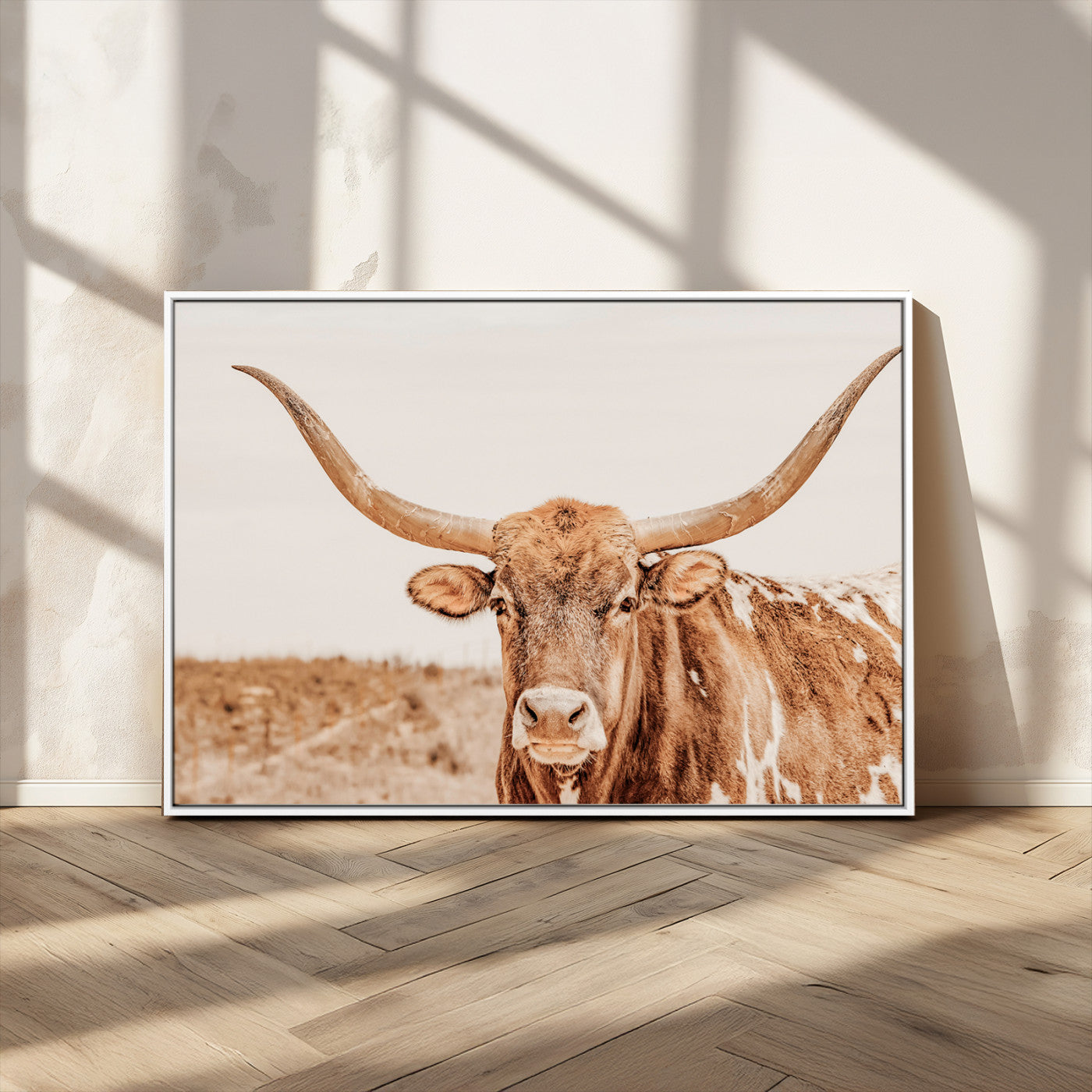 A longhorn bull standing proudly in a sunlit desert field with warm neutral tones, ideal for rustic western or farmhouse interiors.