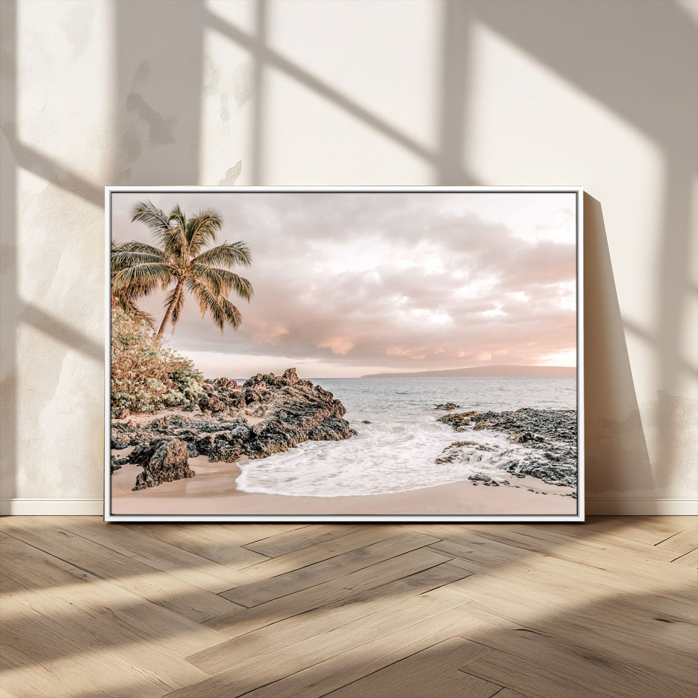 A peaceful beach scene with a palm tree and rocks, soft waves washing onto the shore under a soft pastel sky at sunset.