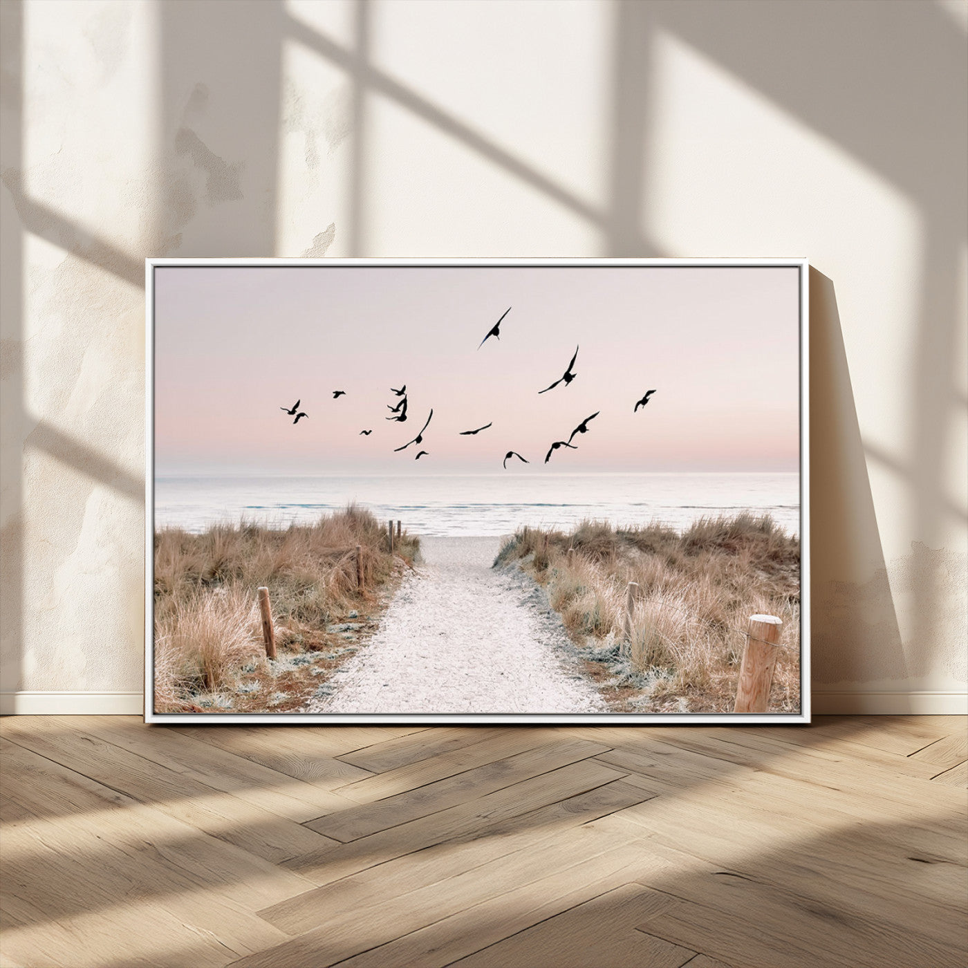 A peaceful coastal pathway leading to the ocean, with birds flying across a soft pastel sky, creating a calm and scenic beach atmosphere.