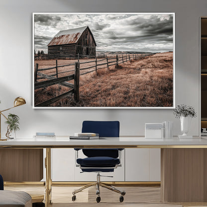 Framed canvas of a rustic barn under a moody sky with weathered fence and dark fields, ideal for farmhouse or rural-style wall decor.