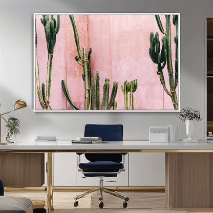 Framed canvas of tall green cacti against a soft pink wall, ideal for modern desert or colorful southwest-inspired home decor.