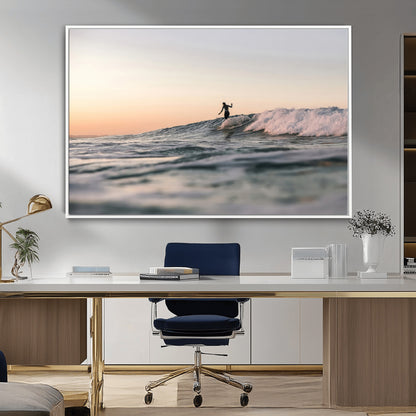Framed canvas of a female surfer balancing on a wave at sunset, perfect for serene surf or ocean-inspired coastal decor.