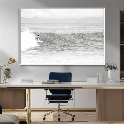 Monochrome photo of a surfer riding a wave with distant mountains, ideal for coastal motion or black and white surf-themed wall decor.