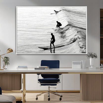Black and white photo of surfers riding waves in a moody, high-contrast scene, ideal for modern coastal or surf-inspired home decor.