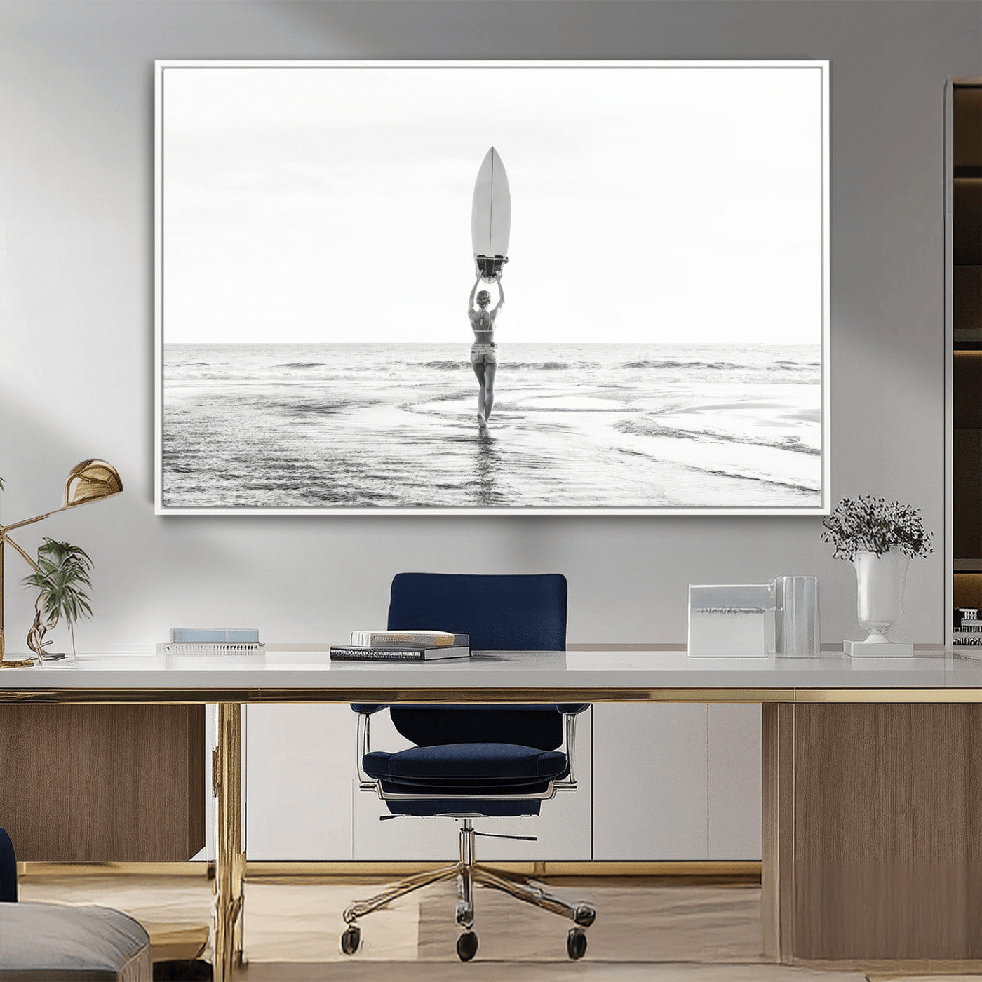 Black and white image of a female surfer holding a surfboard above her head while walking toward the ocean, creating a minimalist and bold coastal aesthetic.