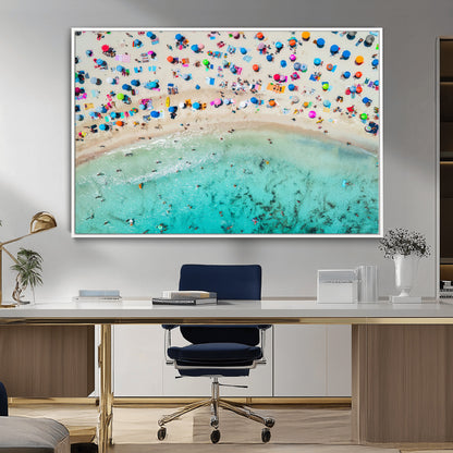 Aerial view of a vibrant beach filled with colorful umbrellas and people enjoying the turquoise ocean, capturing a lively summer vacation scene.