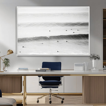 A monochrome photograph of swimmers gliding through gentle ocean waves, evoking a sense of calm and movement.