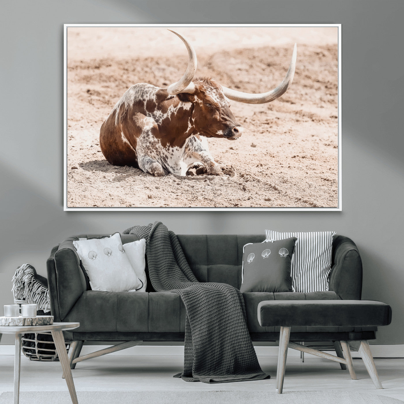 Texas Longhorn bull resting on dusty ground with warm tones, ideal for rustic western or farmhouse-themed wall decor.