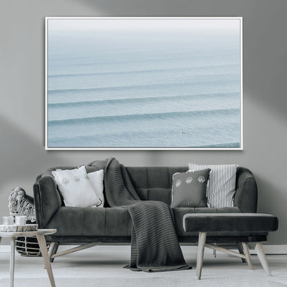 Framed canvas of repeating ocean waves with a distant solo surfer, ideal for minimalist ocean or calm coastal wall decor.