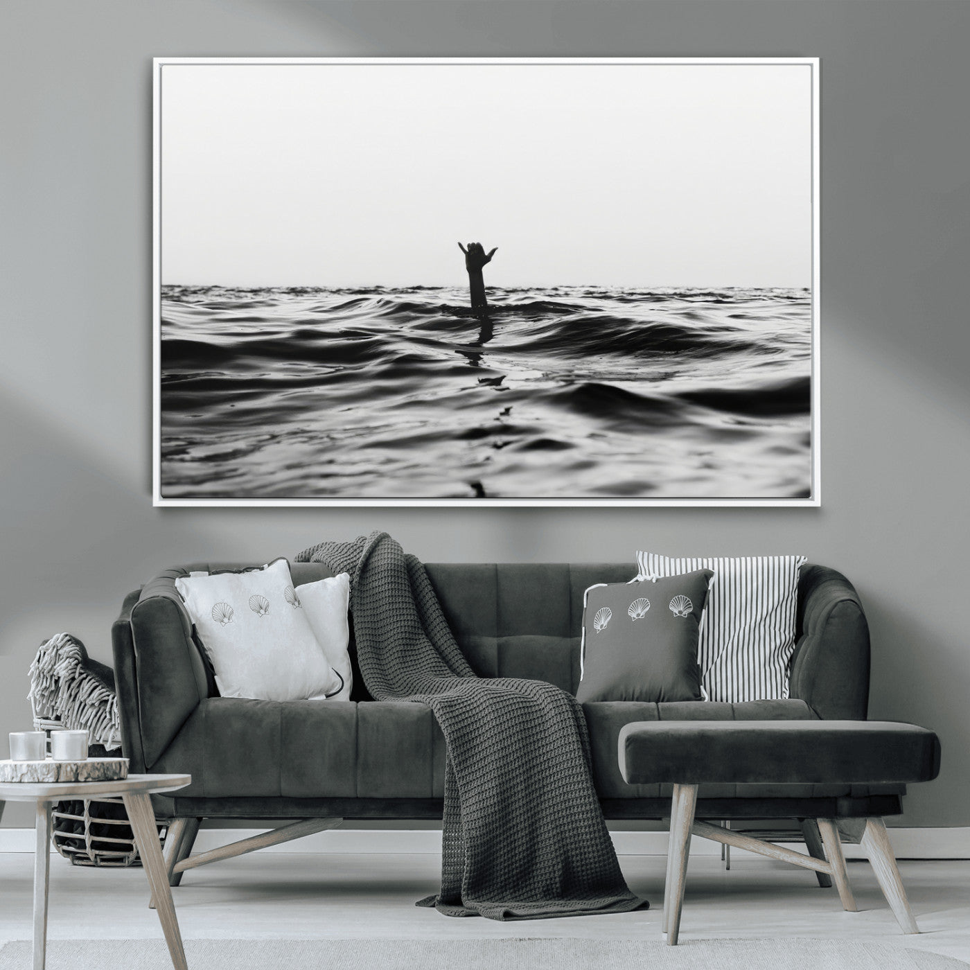 Black and white ocean with a hand making a surfer sign among dark waves, creating a dramatic and minimalist seascape with bold contrast.