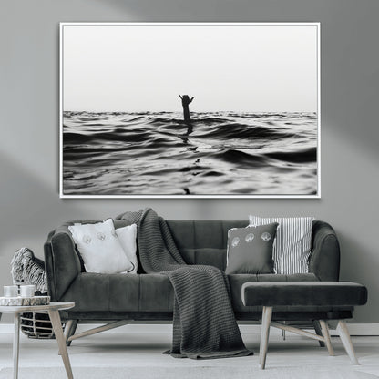 Black and white ocean with a hand making a surfer sign among dark waves, creating a dramatic and minimalist seascape with bold contrast.