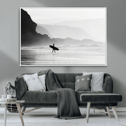 A lone surfer walking along a misty beach with cliffs in the background, carrying their board, capturing a serene and minimal ocean moment.