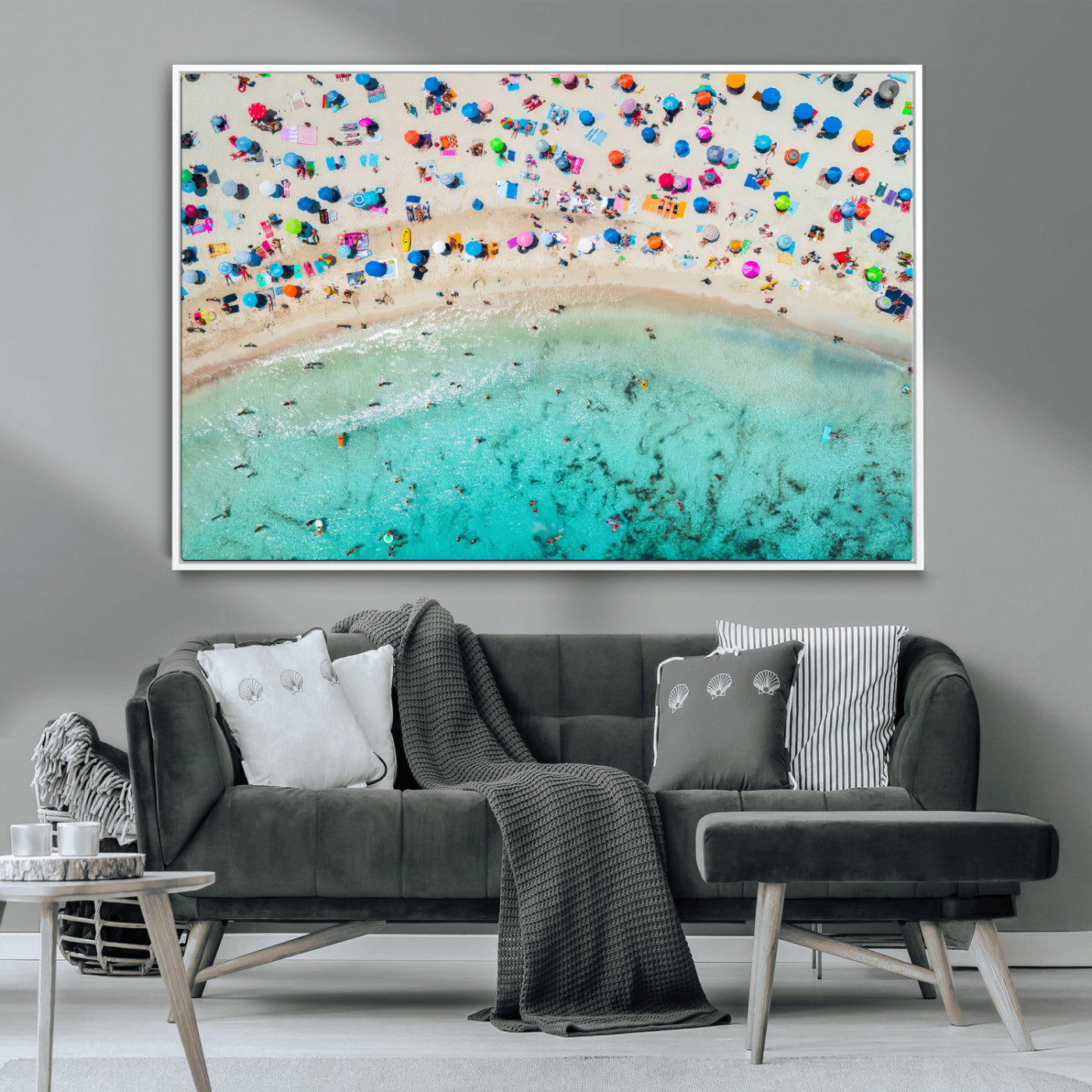 Aerial view of a vibrant beach filled with colorful umbrellas and people enjoying the turquoise ocean, capturing a lively summer vacation scene.