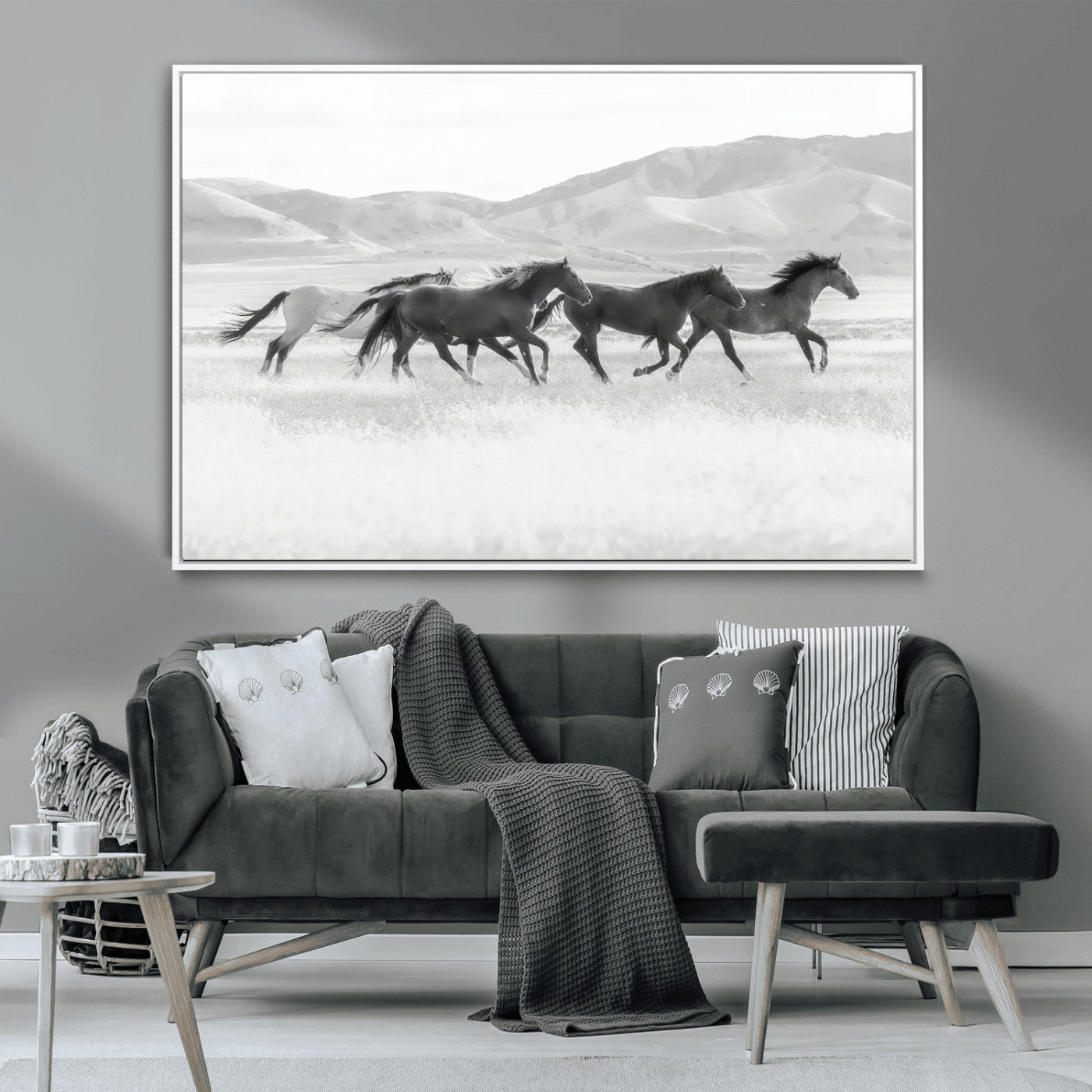 A black and white image of wild horses running freely across an open grassland, capturing the power and beauty of untamed nature in a rustic western setting.