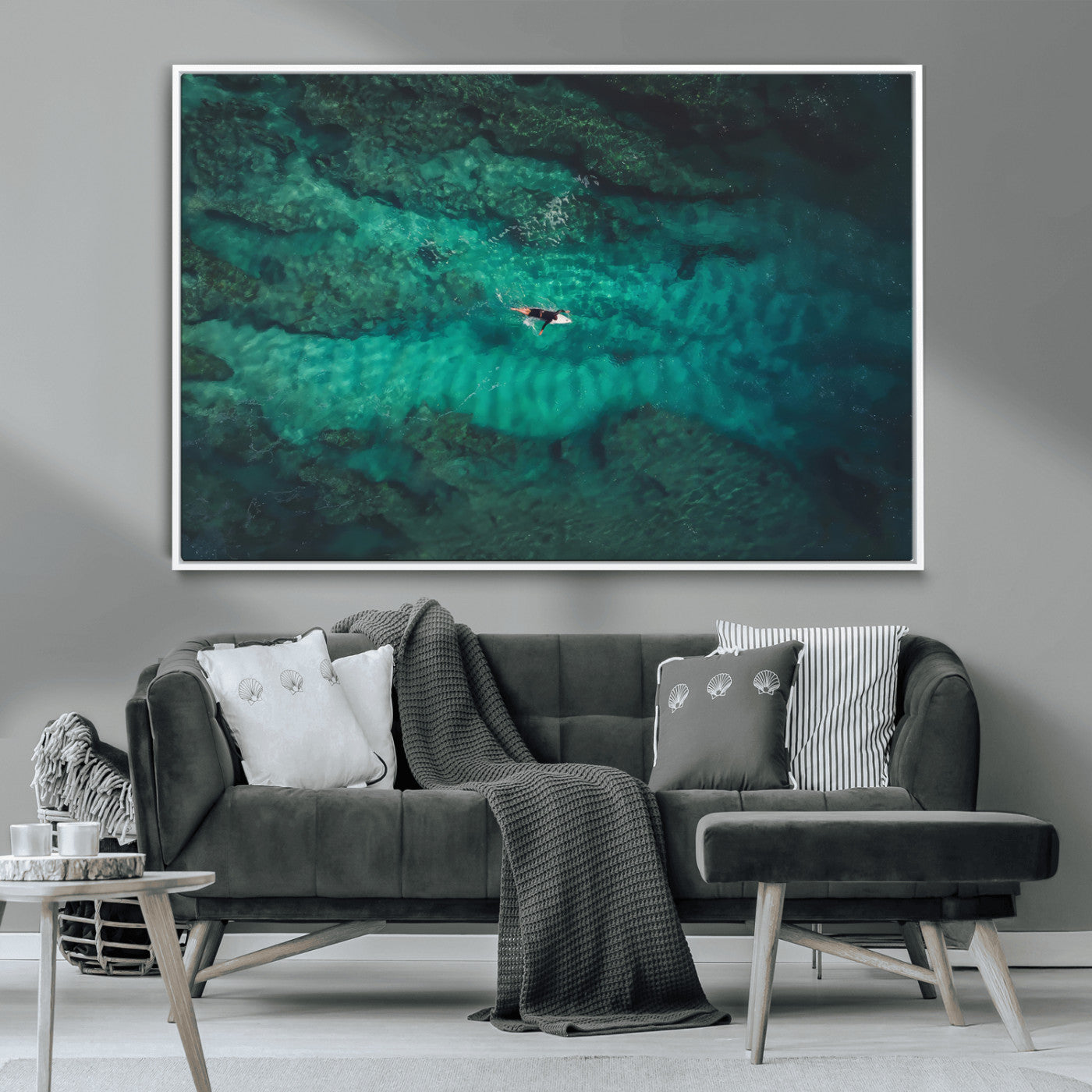 An aerial view of a solo surfer paddling through crystal-clear turquoise waters over a sunlit reef, capturing the beauty and serenity of open water surfing.