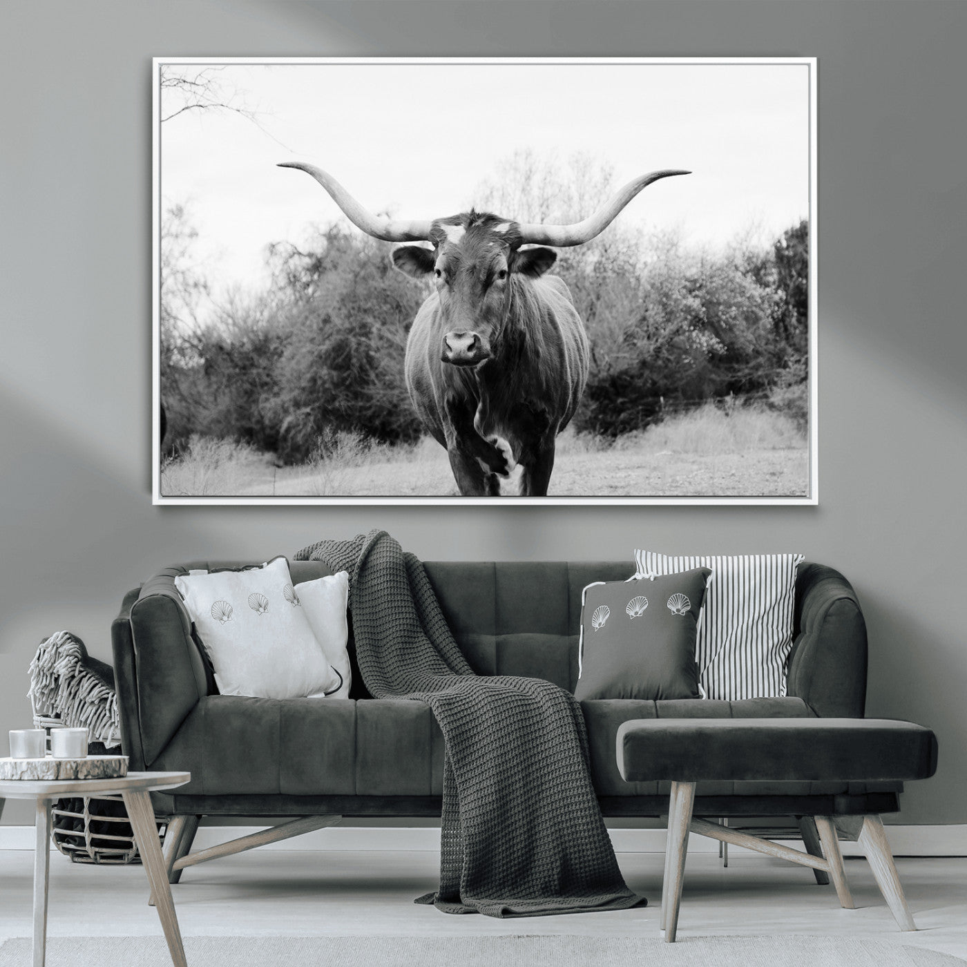 Black and white photo of a longhorn cow in a field, perfect for rustic farmhouse or western-themed interior wall decoration.