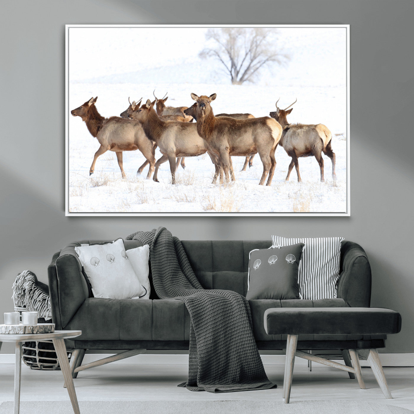 A group of elk standing on snowy terrain with a tree in the background, perfect for rustic or lodge-style winter wall decor.