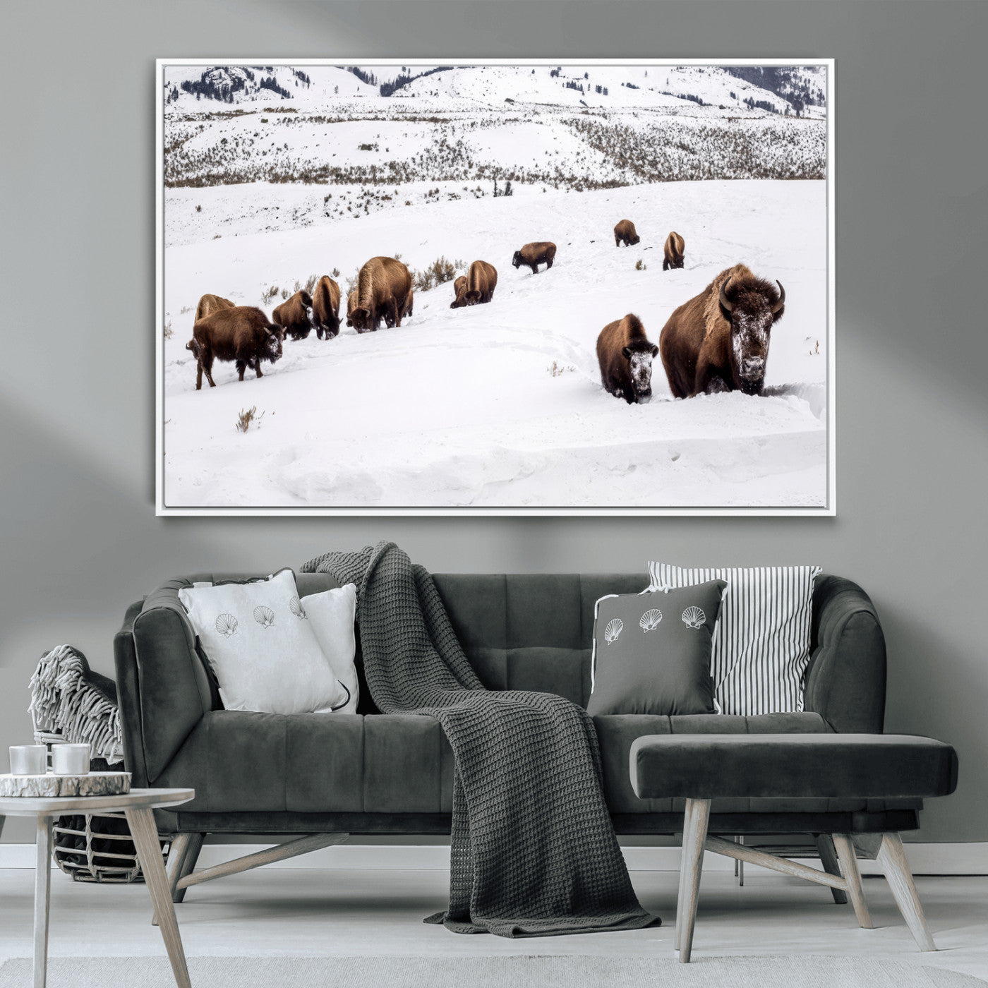 A herd of bison walking through deep snow in a mountain valley, perfect for rustic, cabin or western-themed wall decor.