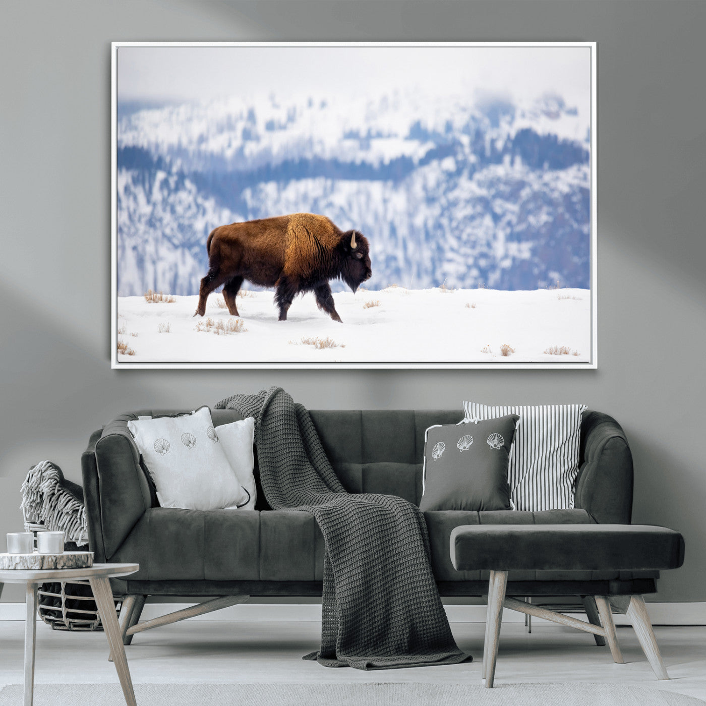 A lone bison walks across snowy ground with blue-toned mountain range behind, ideal for rustic or western farmhouse interiors.