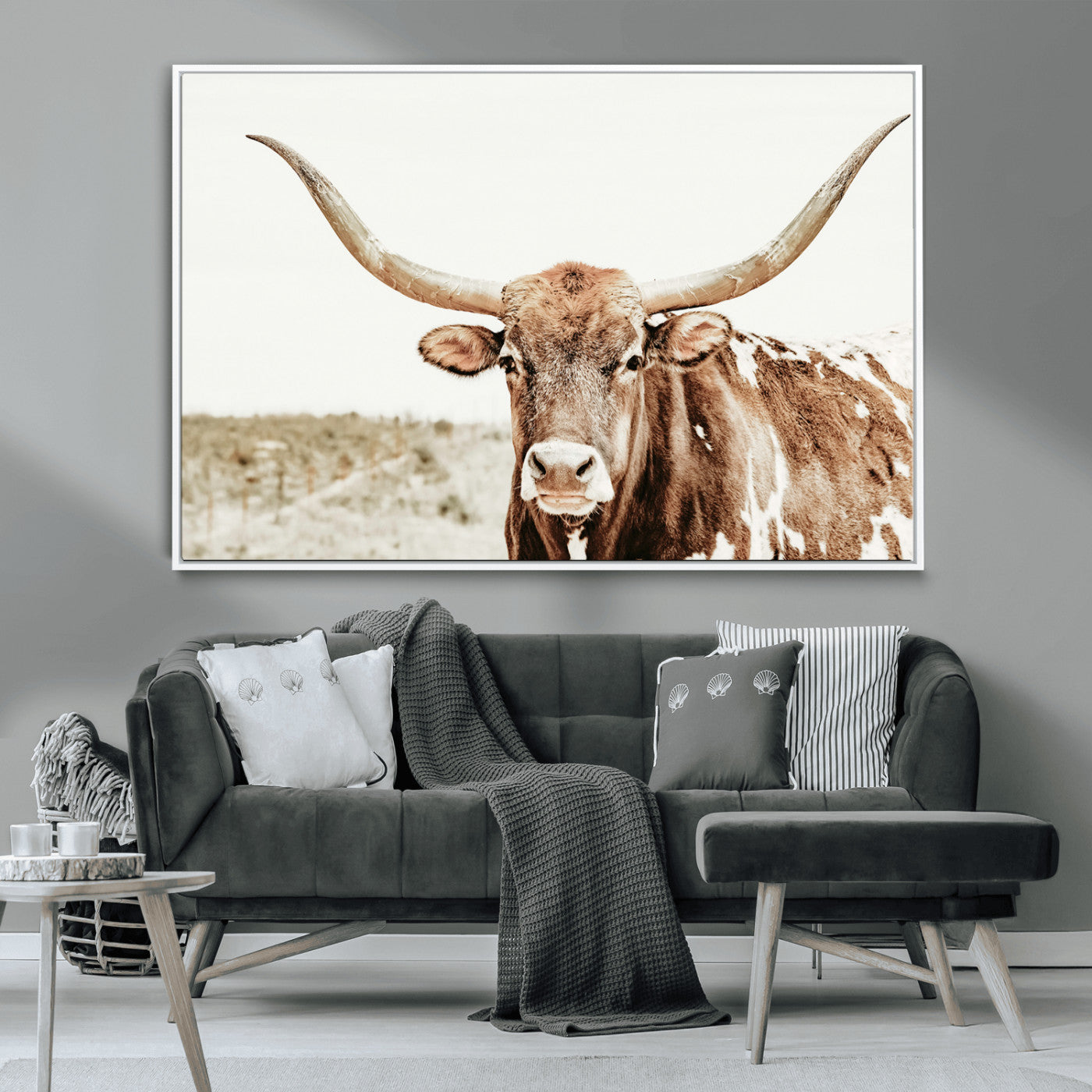 A Texas longhorn bull with wide horns, standing in a dry field under soft light, ideal for rustic farmhouse or western-themed interiors.