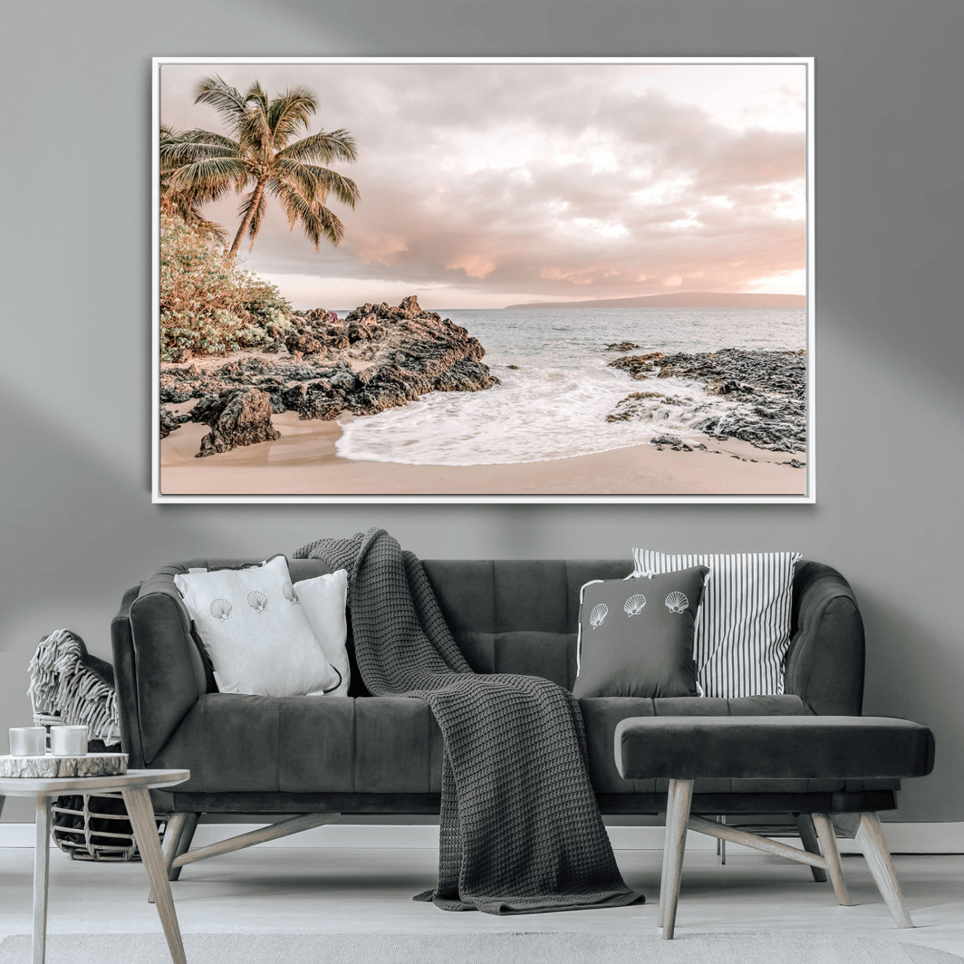 A peaceful beach scene with a palm tree and rocks, soft waves washing onto the shore under a soft pastel sky at sunset.
