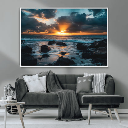 An awe-inspiring sunset over the ocean with rays of light piercing through dramatic clouds, creating a beautiful seascape with rocks in the foreground.