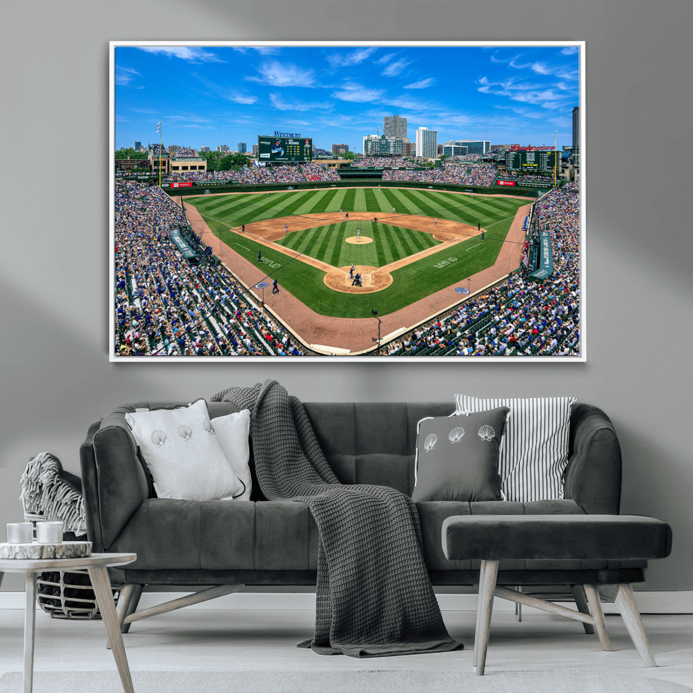 A wide-angle shot of a baseball field filled with spectators, with players on the field and the iconic Wrigley Field scoreboard in the background.