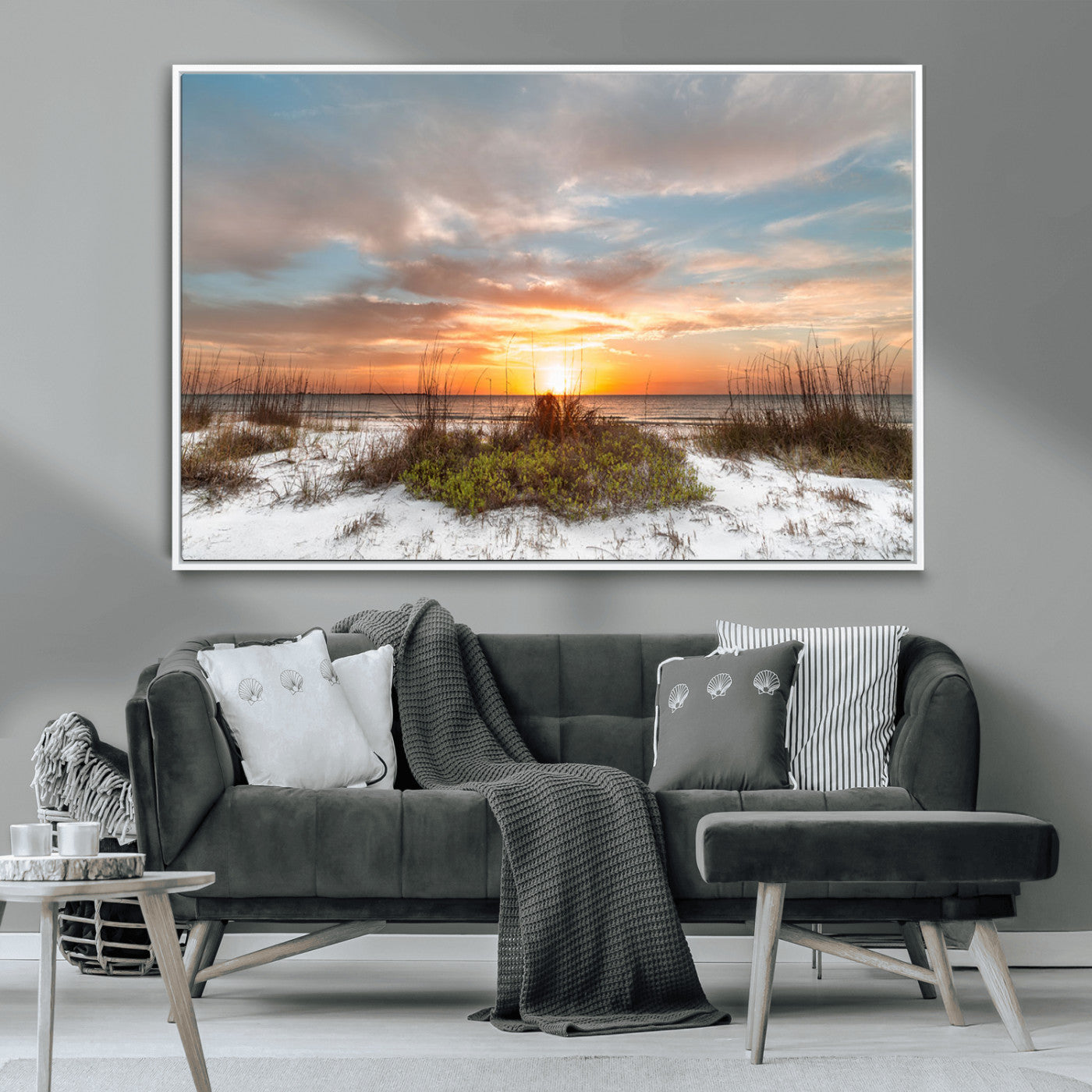 A tranquil beach scene featuring golden sunset hues over the water, with grasses in the foreground and a peaceful, serene atmosphere.