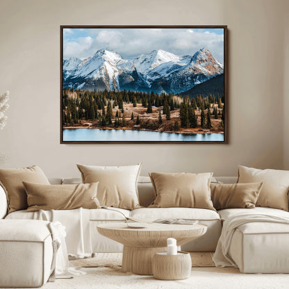 Framed canvas of snowy mountain peaks with pine forest and alpine lake, perfect for winter cabin or wilderness-inspired home decor.
