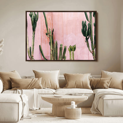 Framed canvas of tall green cacti against a soft pink wall, ideal for modern desert or colorful southwest-inspired home decor.