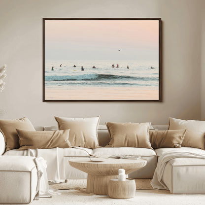 Dreamy photo of surfers waiting on soft pastel waves under a pink sunset sky, ideal for soft coastal minimalist or serene ocean-themed home decor.