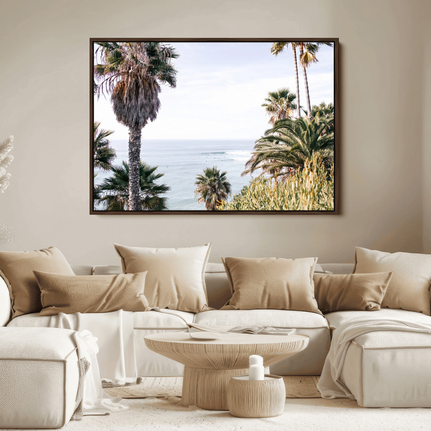 Scenic coastal view with tall palm trees overlooking a calm ocean, soft blue waves, and surfers in the distance, creating a peaceful tropical vibe.