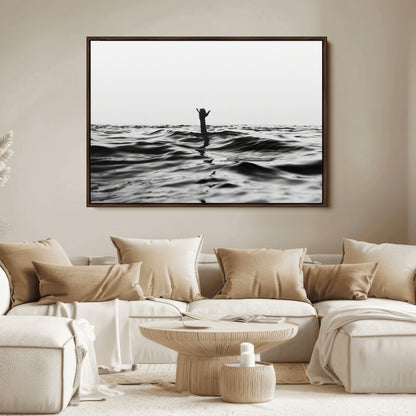 Black and white ocean with a hand making a surfer sign among dark waves, creating a dramatic and minimalist seascape with bold contrast.