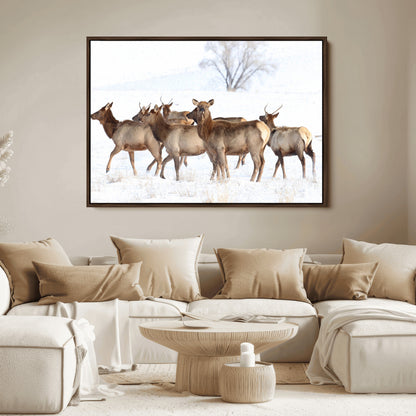 A group of elk standing on snowy terrain with a tree in the background, perfect for rustic or lodge-style winter wall decor.