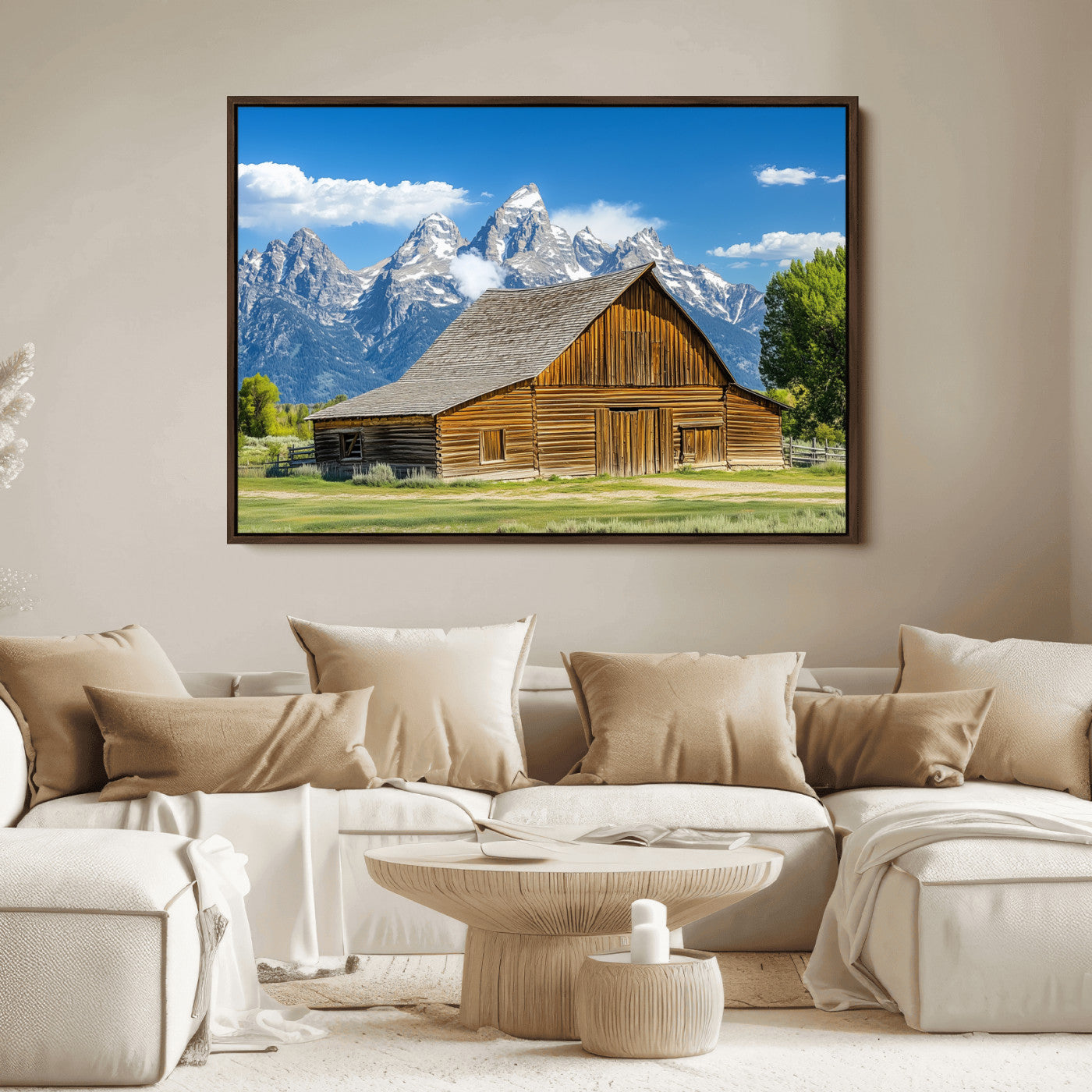 A rustic wooden barn sits in front of towering mountain peaks under a clear blue sky, perfect for farmhouse or cabin style interiors.
