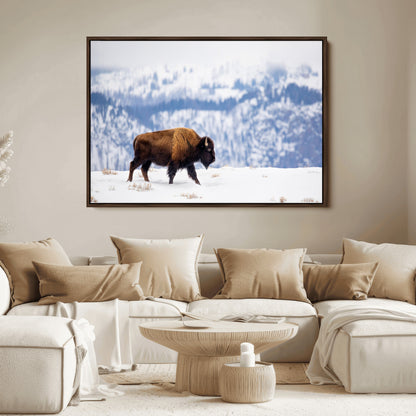 A lone bison walks across snowy ground with blue-toned mountain range behind, ideal for rustic or western farmhouse interiors.