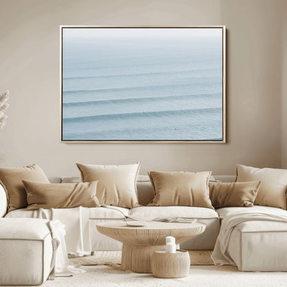 Framed canvas of repeating ocean waves with a distant solo surfer, ideal for minimalist ocean or calm coastal wall decor.