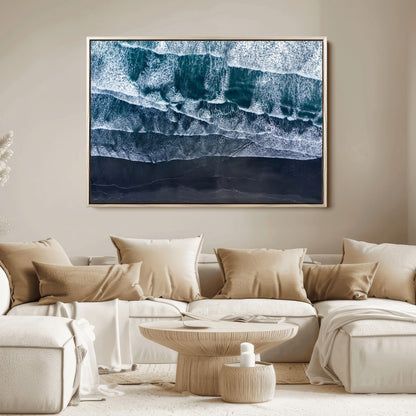 Canvas of aerial ocean waves crashing onto a black sand beach in moody tones, ideal for modern coastal or minimalist home decor.