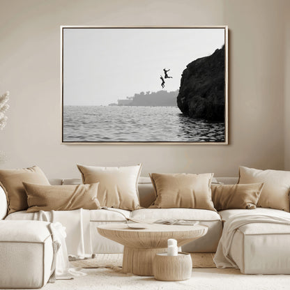 Black and white canvas of two figures cliff jumping into the sea, captured with moody tones, ideal for modern coastal or adventure-themed home decor.   2/2