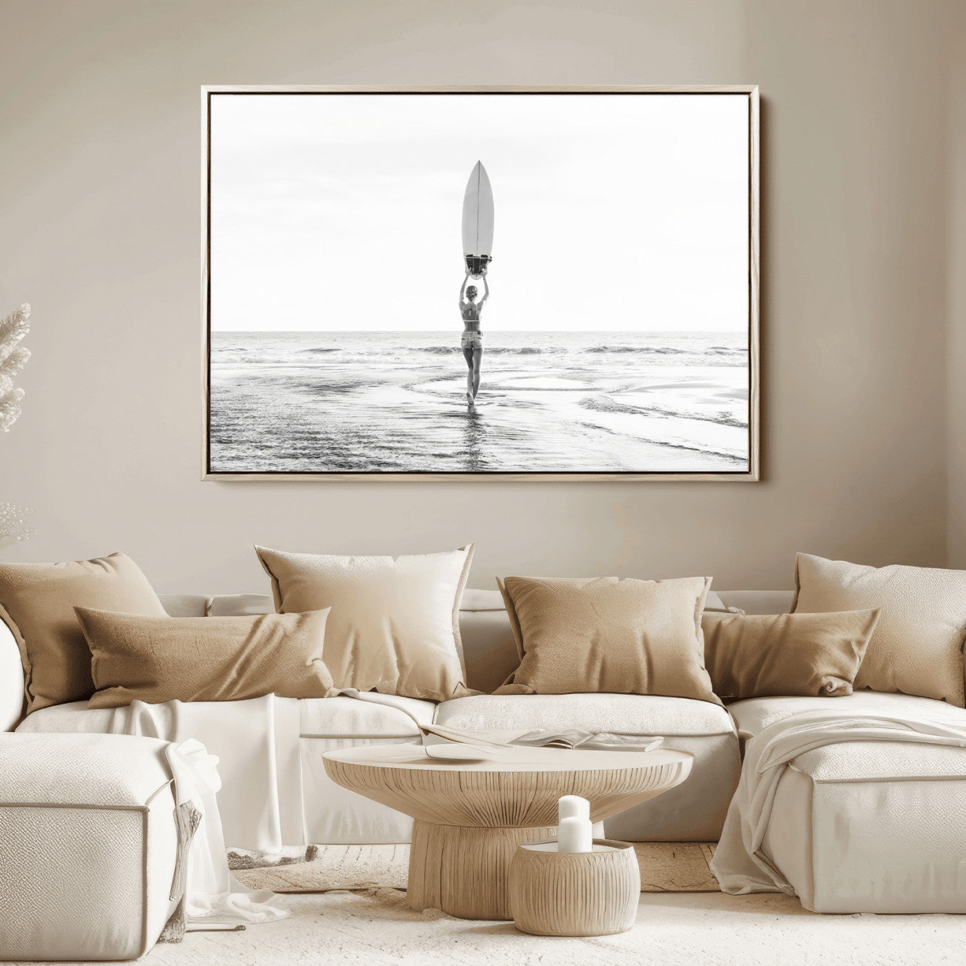 Black and white image of a female surfer holding a surfboard above her head while walking toward the ocean, creating a minimalist and bold coastal aesthetic.